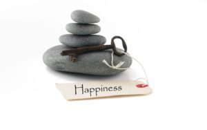Happiness - stack of stones with key and Happiness tag